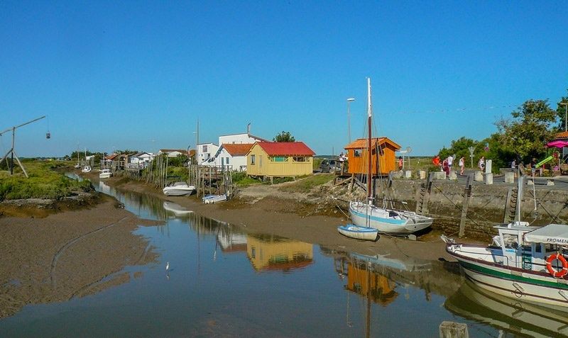 Port de Mornac-sur-Seudre à marée basse, bordé de barques et de cabanes